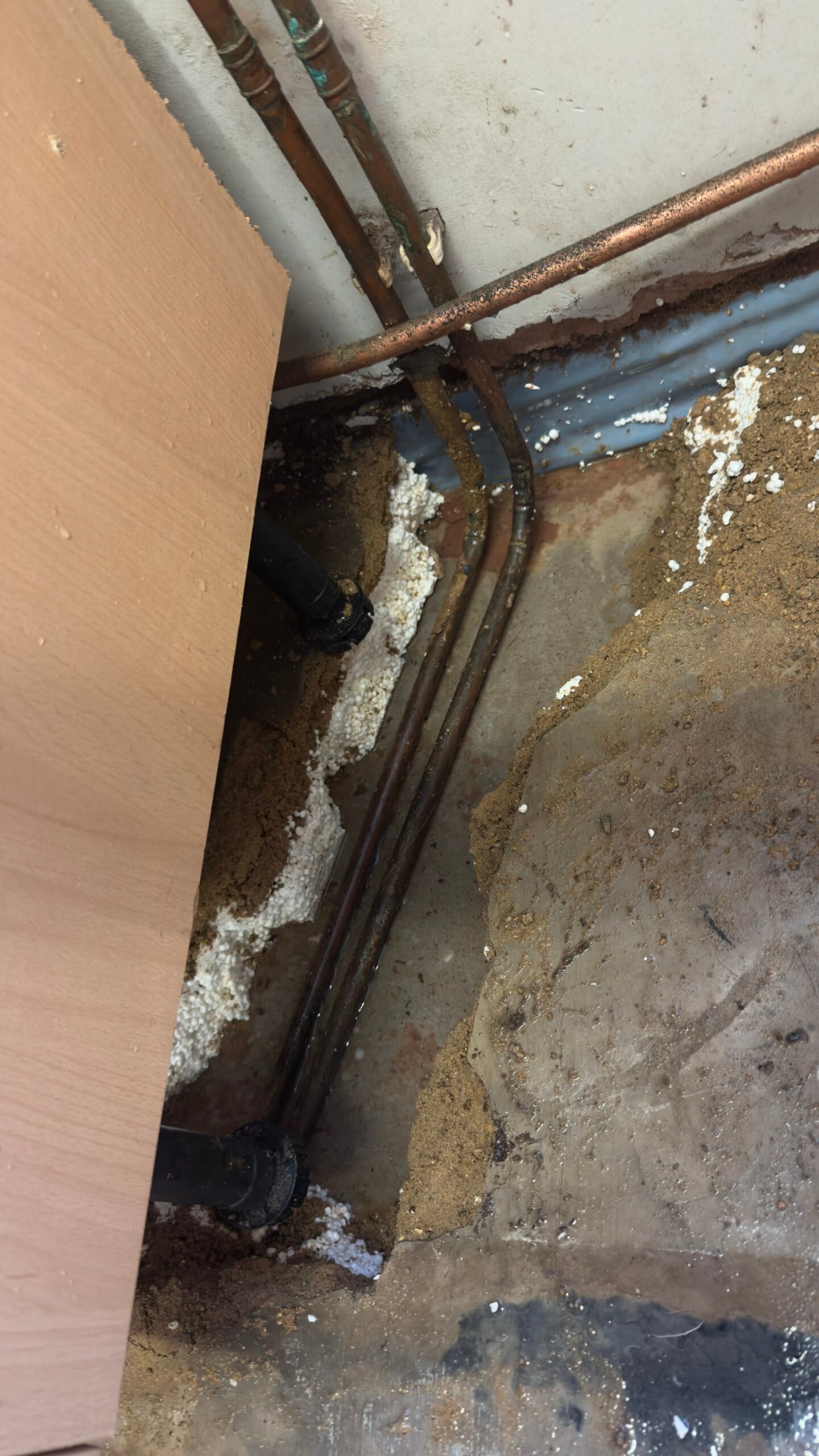 Old corroded pipework exposed under kitchen floor 